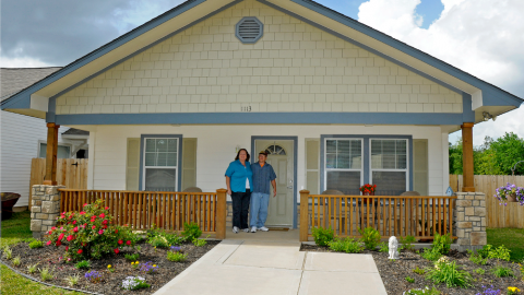 Housing Initiative clients in front of their home