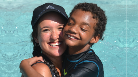 Counselor and camper smiling in pool